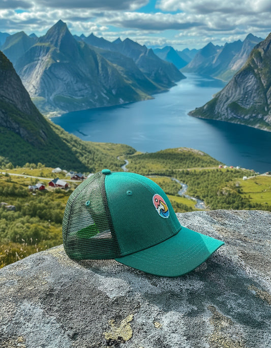 Trucker Cap Teal – capsen på en stein høyt over en fjord