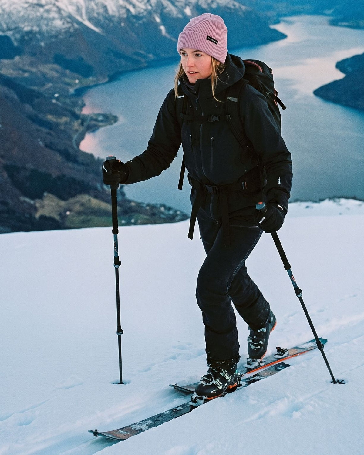 Pink Captain Merino Beanie – kvinne på topptur over fjorden i soloppgang