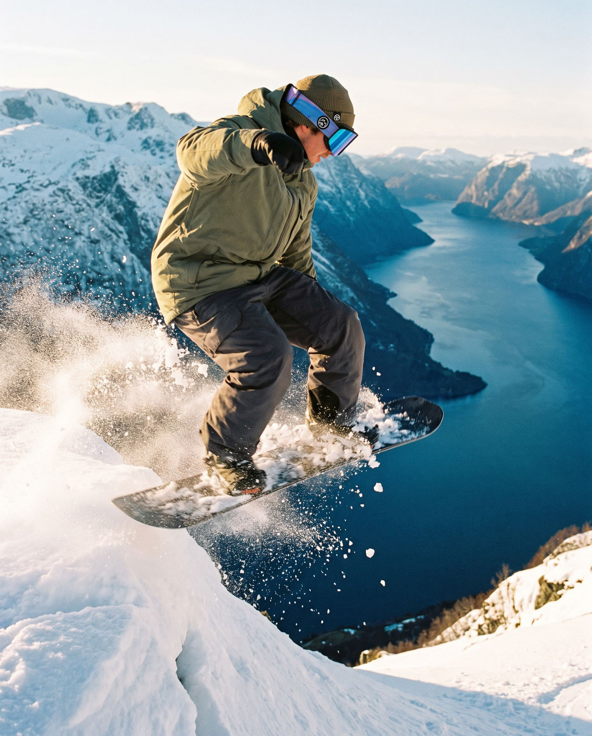 Pure Shred Goggles – snowboarder i luften med gogglesene over en fjord med snødekte fjell