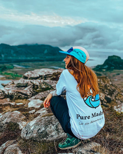 Let the Adventure Begin White Tee – kvinne sitter på huk på fjellet med baktrykket synlig