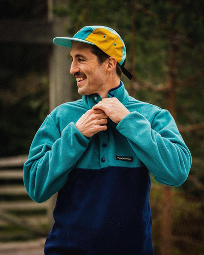 Polar Fleece – smilende mann med caps i turkis og marineblå fleece i skogen